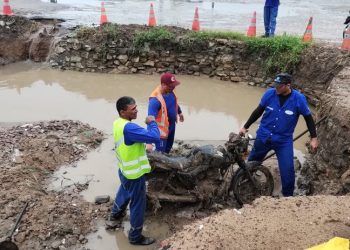 Operários retiram moto de bueiro durante obras de desobstrução em Bayeux