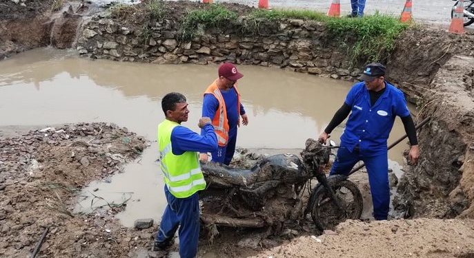 Operários retiram moto de bueiro durante obras de desobstrução em Bayeux